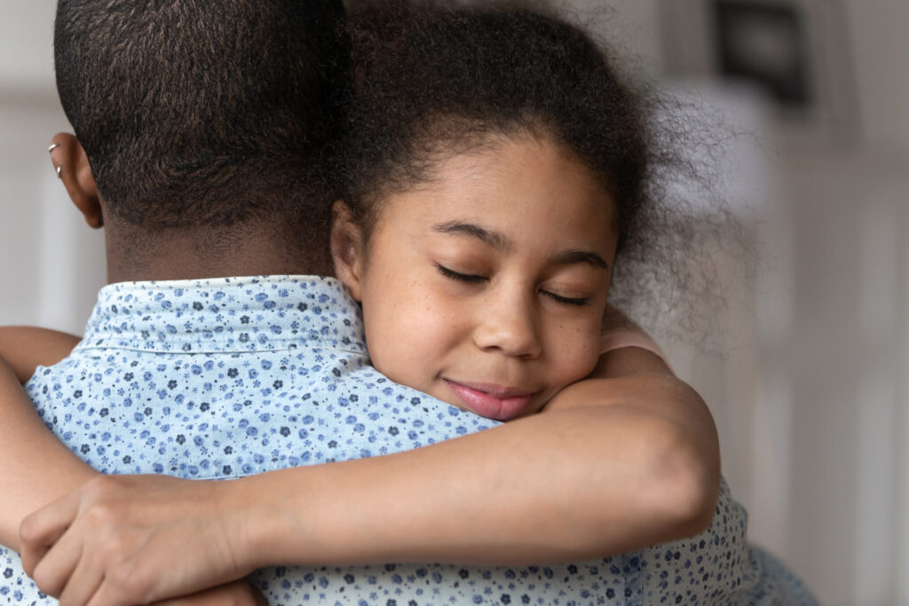 Close up of cute little black girl embrace african American dad have tender moment together show love and care, sensitive biracial kid daughter hug father happy to reunite after family separation